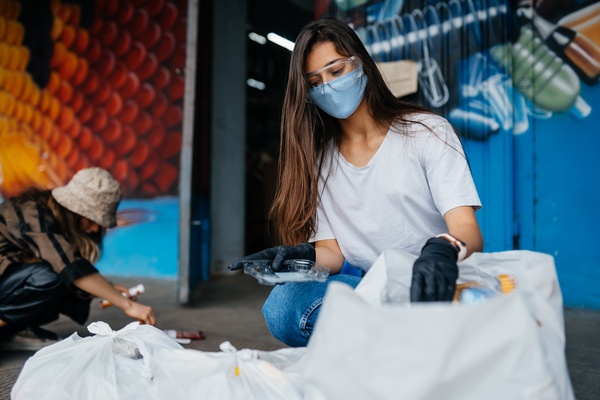 Jovem classificando o lixo para reciclagem. Saiba mais sobre a parceria Positiv.a + eureciclo!