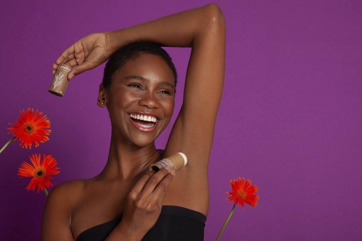 Mulher negra passando desodorante natural na axila