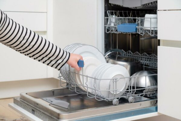 pessoa abrindo sua máquina de lavar louças após lavar todos os seus utensílios com um sabão recomendado e ideal