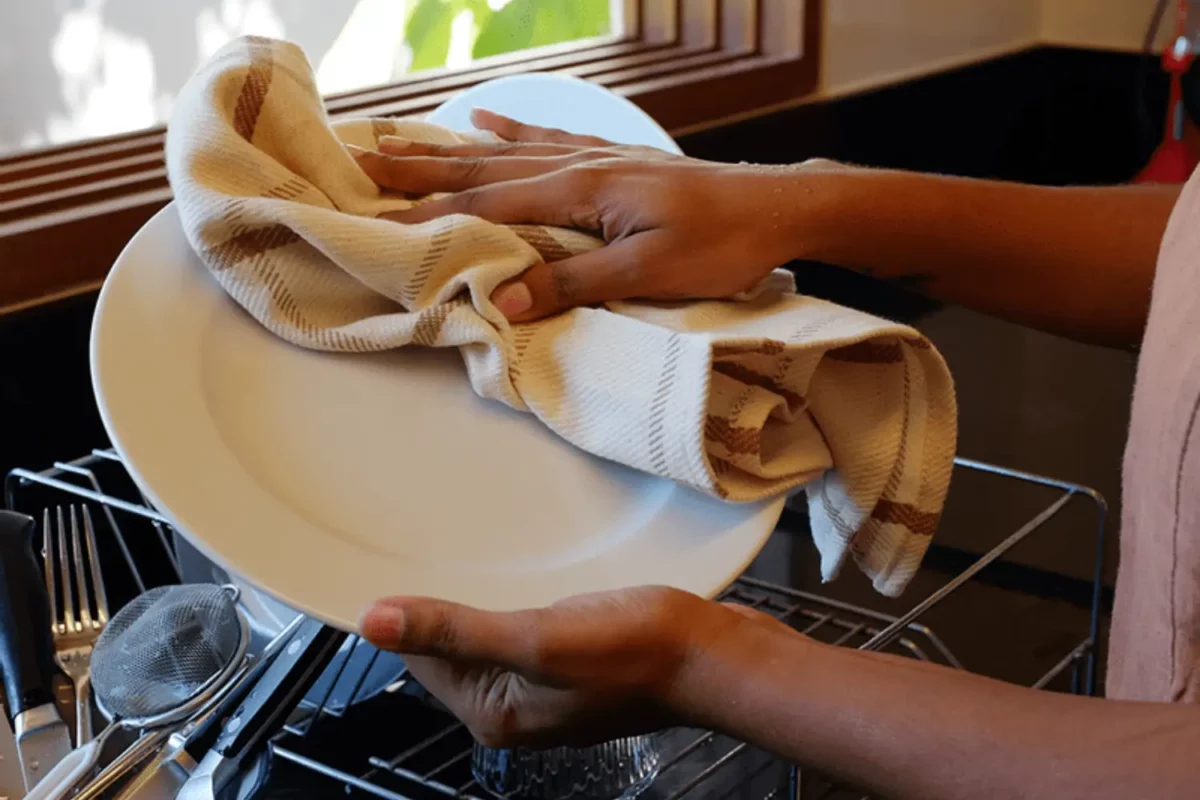 Mulher secando a louça com pano de algodão orgânico da positiv.a.